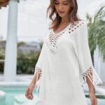 Femme brune dans une robe courte blanche avec franges et macramé