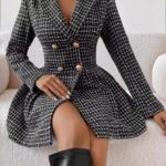 Femme assise sur canapé blanc qui porte robe blazer à carreaux très chic