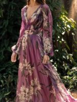 Robe bohème chic en mousseline violette à fleurs, portée par une femme devant des feuillages.