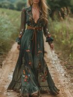 Robe bohème chic verte à fleurs portée avec une ceinture marron, par une femme qui marche dans un chemin au milieu d'un champs.