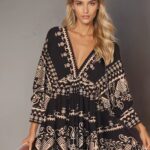 Photo d'une femme portant une robe bohème courte à manches longues, noire à motifs.