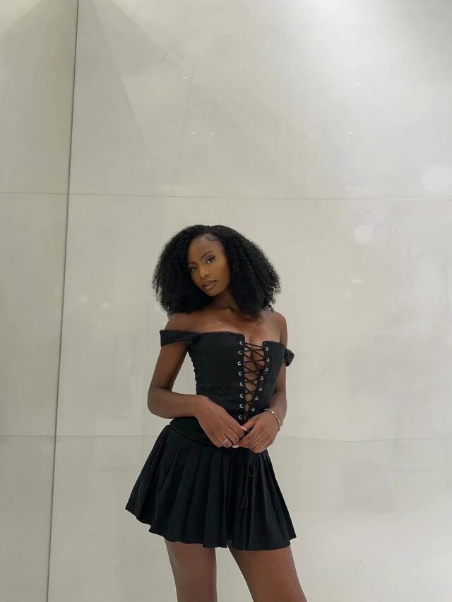 Femme portant une robe noire courte.