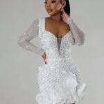 Femme portant une robe blanche à strass.