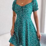 Photo d'une femme portant une robe fleurie verte à manches courtes bouffantes
