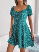 Photo d'une femme portant une robe fleurie verte à manches courtes bouffantes