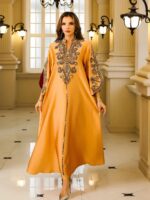 Photo d'une femme portant une robe kabyle orange brodée de soirée et marchant dans un couloir de palace
