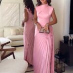 Femme portant une robe rose longue.