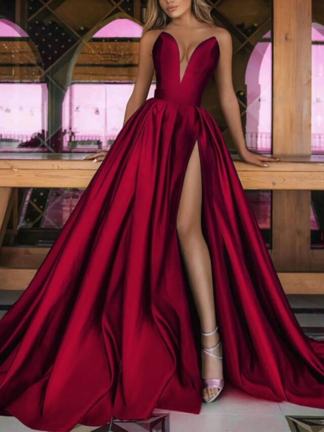 Photo d'une robe princesse rouge avec un bustier en V et une fente porté par une femme