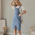 femme blonde robe salopette en jean dans un salon moderne en arriere plan