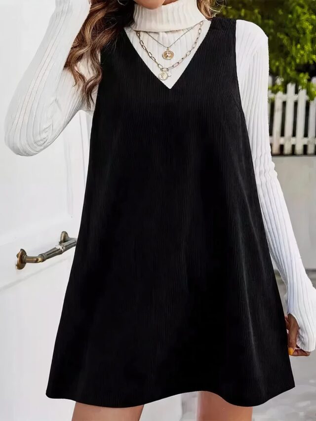 Femme brune qui porte une robe noire style salopette en velours côtelé