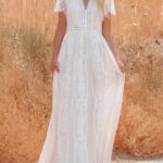 Photo d'une femme portant une robe bohème chic en dentelle longue blanche à manches courtes.