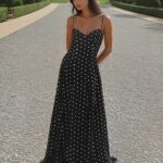Photo d'une femme portant une robe longue d'été à pois dans une allée extérieur.